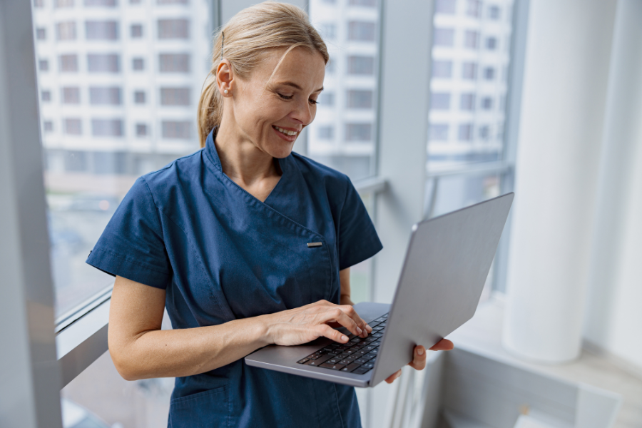 therapist smiling while holding laptop