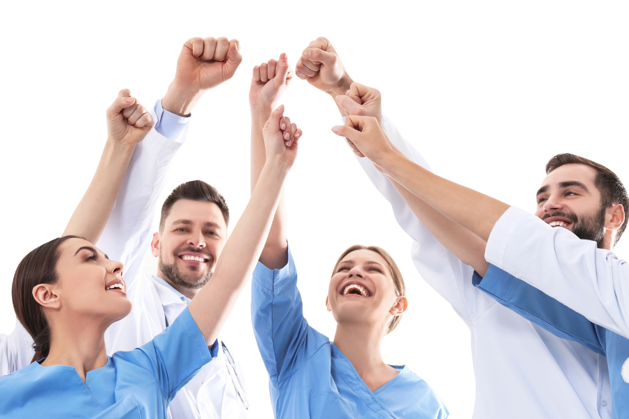 Clinicians raising their hands in celebration, representing teamwork and improved workflows enabled by ScribePT’s embedded AI in modern EMR platforms.