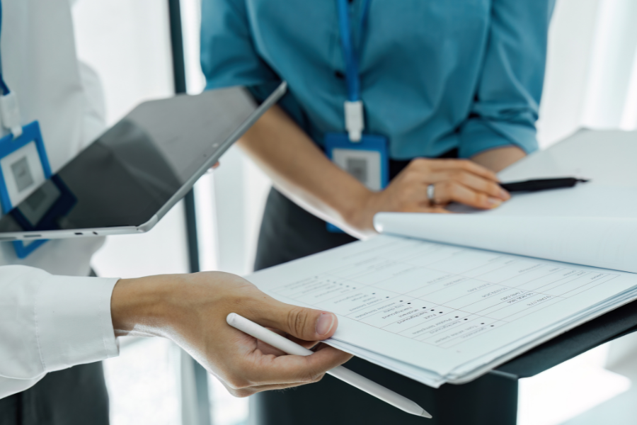 Professionals in a modern office review critical medical records, illustrating the vital need for accurate rehab therapy documentation. Using general AI scribes leads to dangerous 'AI hallucinations' in clinical notes, which are a major liability. Avoid compliance and billing risks by upgrading from generic tools to ScribePT—the specialized AI documentation engine for physical, occupational, and speech therapy that ensures accurate EMR notes.
